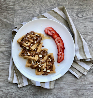 Gluten-free almond flour waffles with chocolate hazelnut butter and strawberries